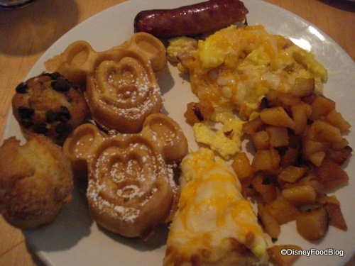 Food plate all ready to go: mickey waffles, eggs, breakfast pizza, homefries, muffins, and sausage
