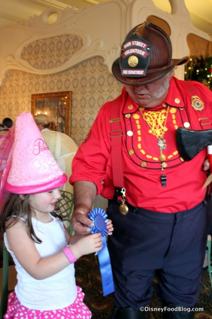 Main Street Fire Chief Gives the Mayor of the Day Badge to a Young Guest