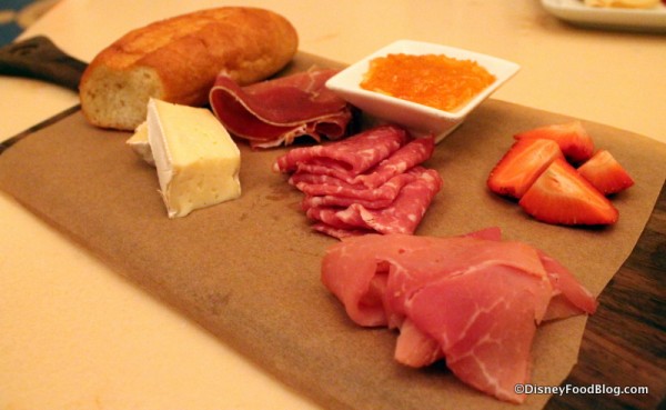 Assorted Cured Meats and Cheeses -- alpine-smoked ham, serrano ham, sopressata, and cheese served with marmalade, fresh fruit, and toasted baguette