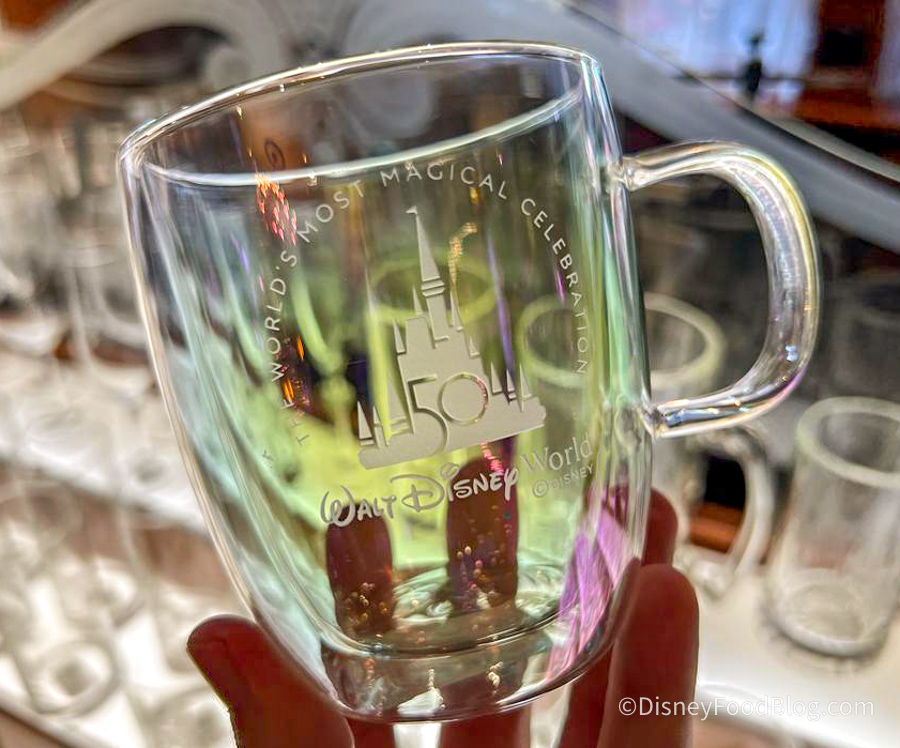 https://www.disneyfoodblog.com/wp-content/uploads/2022/11/2022-wdw-mk-crystal-arts-iridescent-earidescent-crystal-coffee-mug-glass-2.jpg